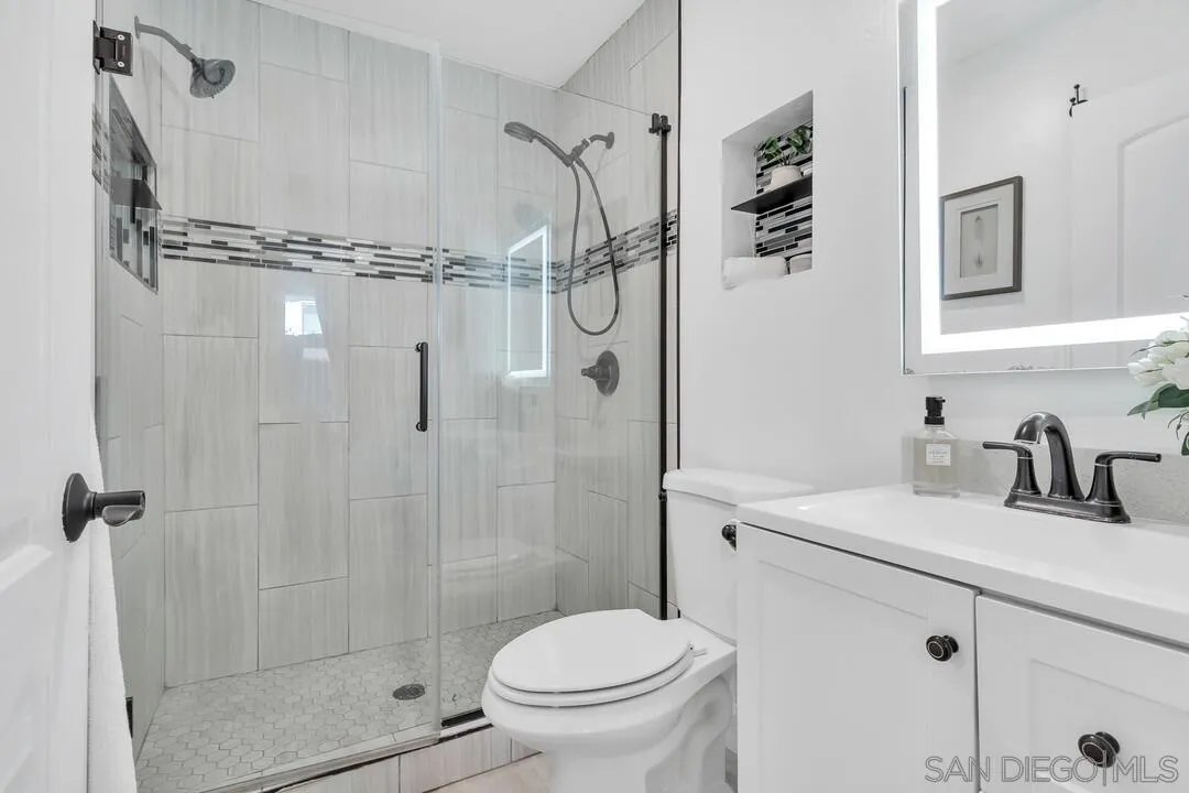11021 Sagittarius Road San Diego, CA 92126 - Photo 16 of 28 a bathroom with a granite countertop sink a toilet and shower