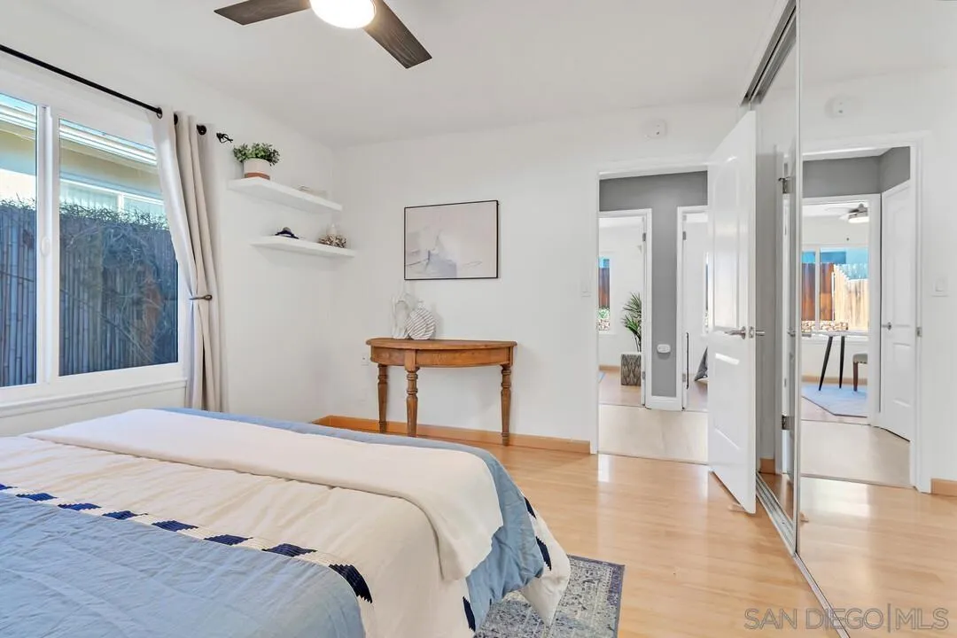 11021 Sagittarius Road San Diego, CA 92126 - Photo 18 of 28 a bedroom with a large bed and a chandelier