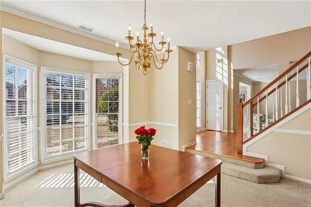 a view of kitchen with dining table and windows