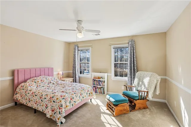 a bedroom with a bed chair and window