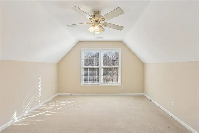 an empty room with a window and a ceiling fan