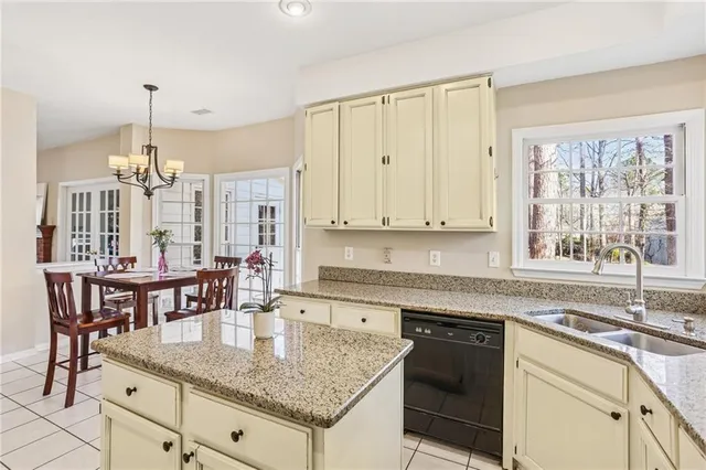 a kitchen with granite countertop a sink a stove and cabinets