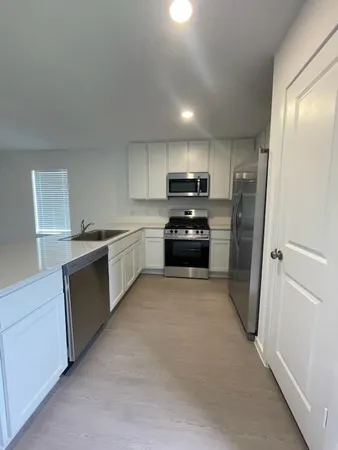 a kitchen with stainless steel appliances a refrigerator sink and stove
