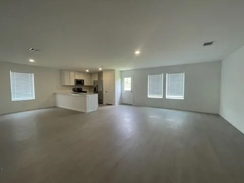 a view of empty room with a kitchen and window