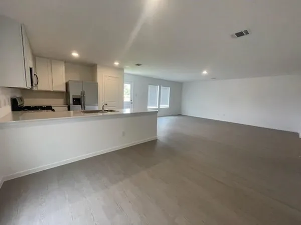 a large kitchen with stainless steel appliances a sink a stove and a refrigerator