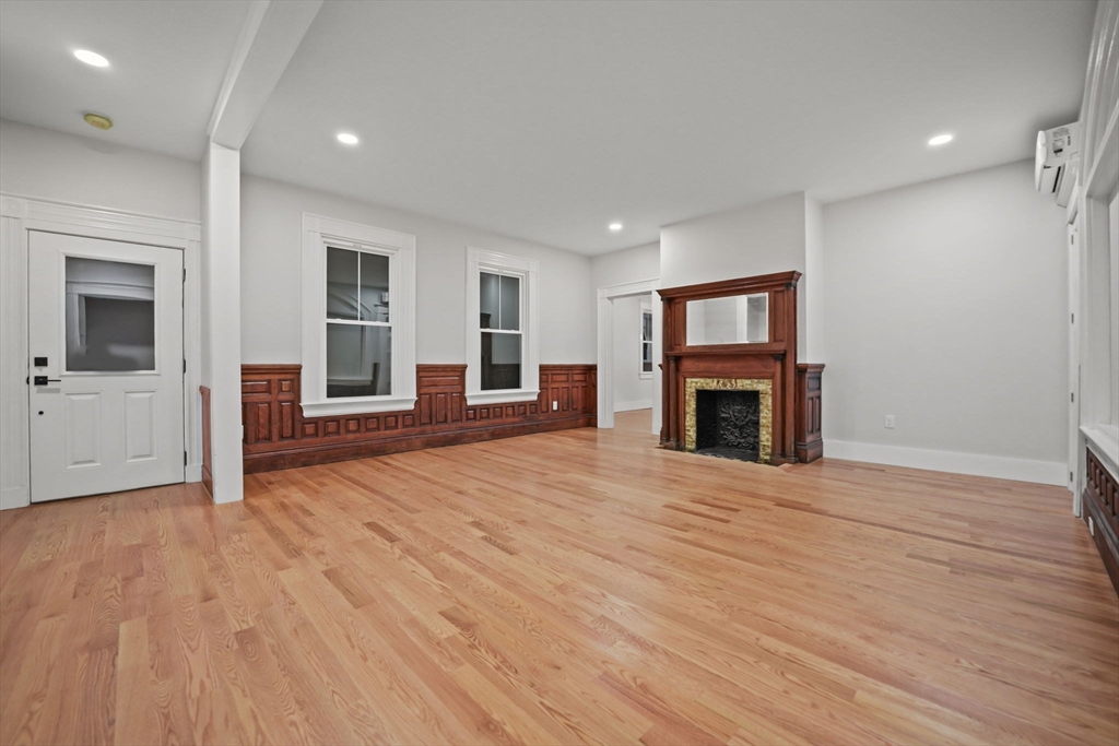 16 Water Street, Unit B Freetown, MA 02702 - Photo 6 of 22 an empty room with wooden floor and fireplace