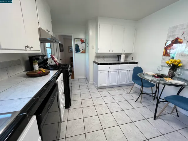 a kitchen with granite countertop a sink a stove and cabinets