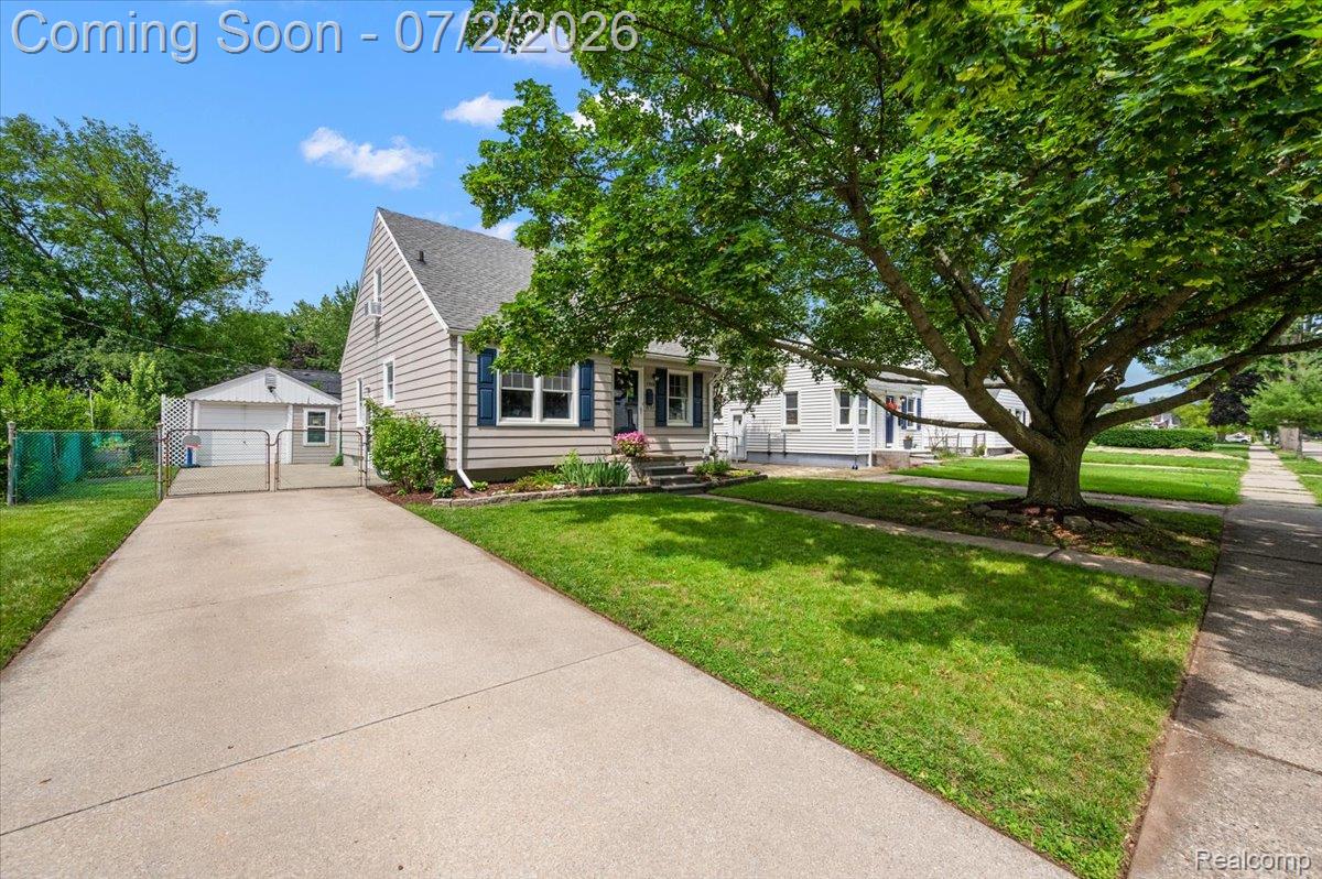1706 Princeton Road Berkley, MI 48072 - Photo 3 of 49 Charming gable-roof residence featuring horizontal siding, a concrete driveway, and a detached garage with a chain-link gate