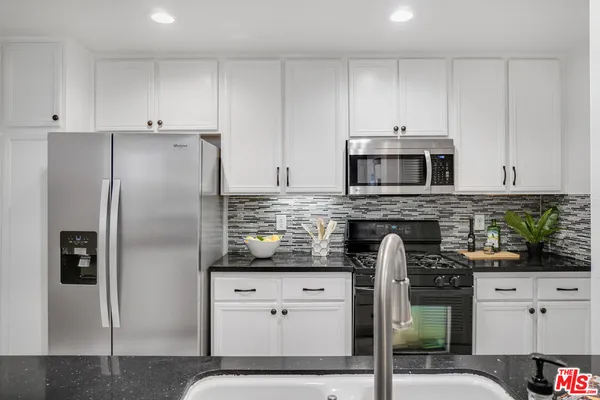a kitchen with stainless steel appliances a stove a sink and a refrigerator
