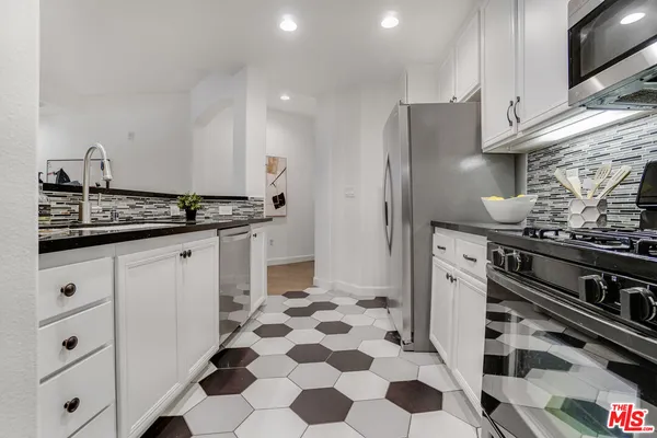 a kitchen with a sink and a stove top oven with wooden floor
