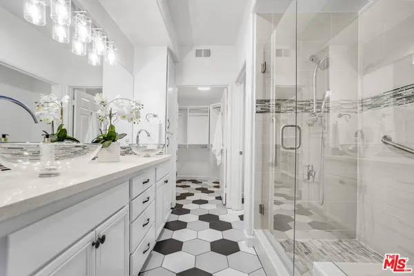 a spacious bathroom with a shower sink and mirror