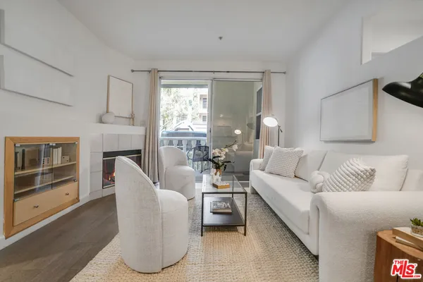 a living room with furniture a fireplace and a large window