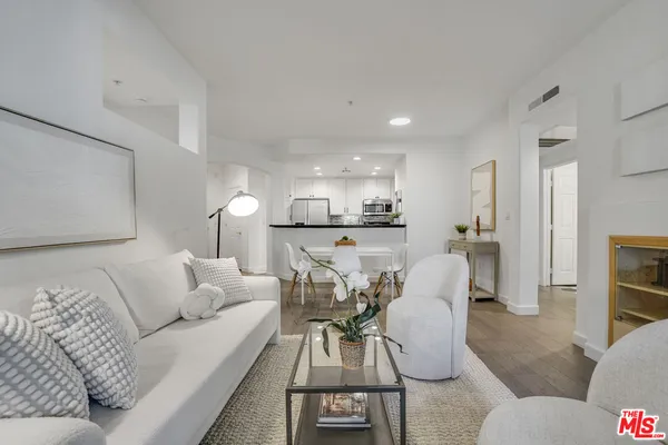 a living room with furniture and a view of kitchen