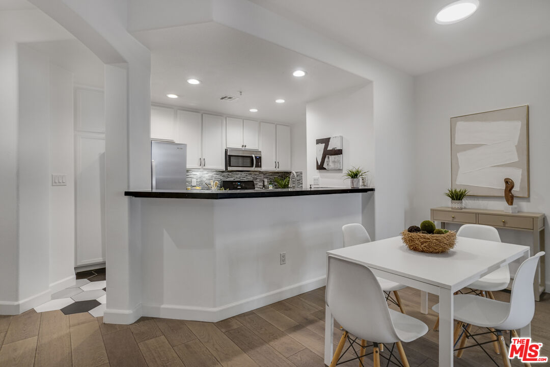 12963 West Runway Road, Unit 121 Playa Vista, CA 90094 - Photo 9 of 46 a kitchen with kitchen island granite countertop a sink cabinets and wooden floor