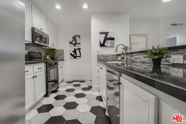 a kitchen with refrigerator a microwave and cabinets