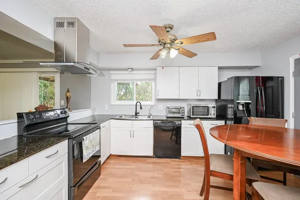 a kitchen with a table chairs stove and cabinets