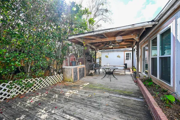a view of a patio with table and chairs potted plants and floor to ceiling window