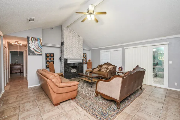 a living room with furniture a fireplace and a large window