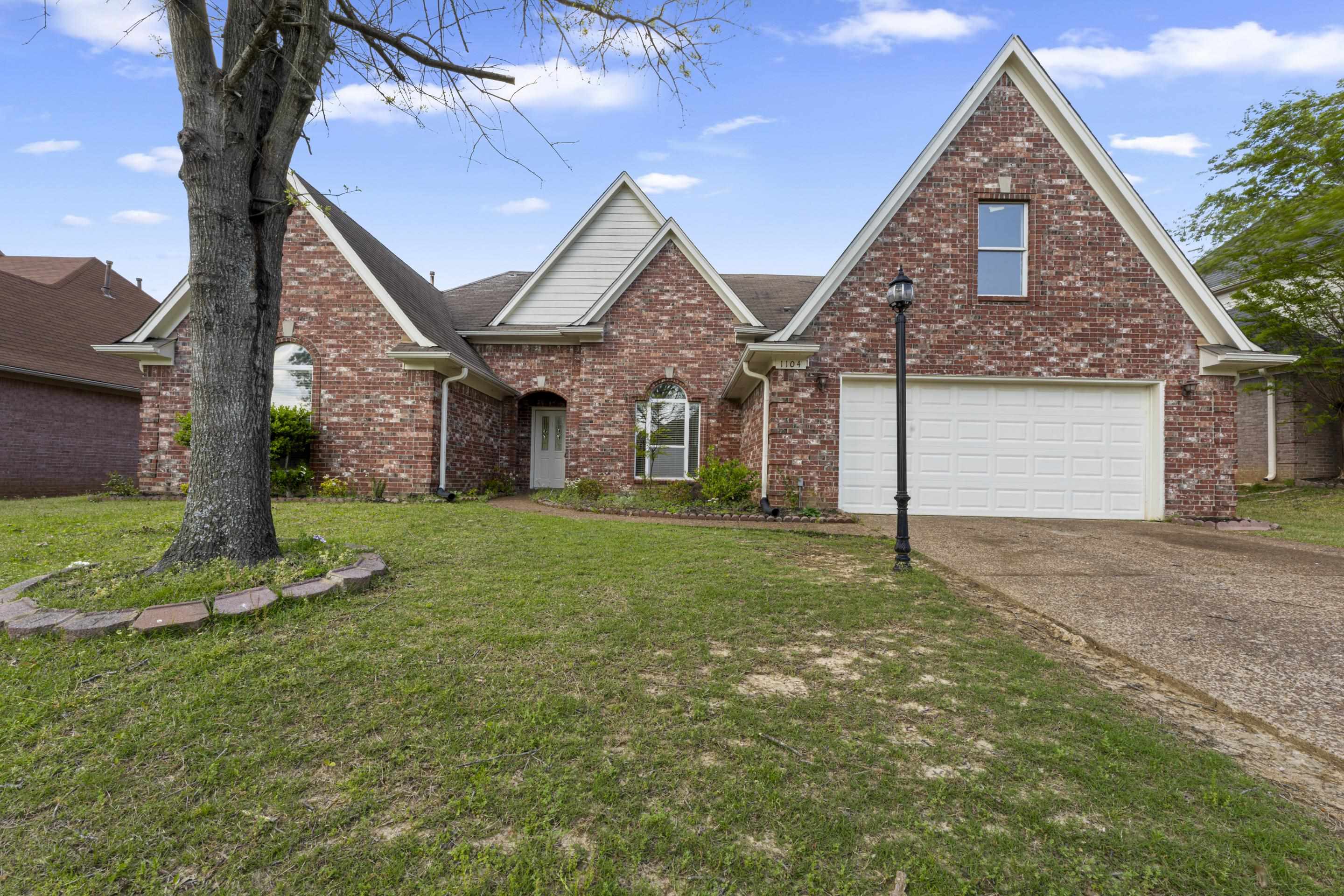 1104 Macon Hall Road Cordova, TN 38018 - Photo 1 of 34 Traditional home with brick siding, driveway, an attached garage, and a front lawn