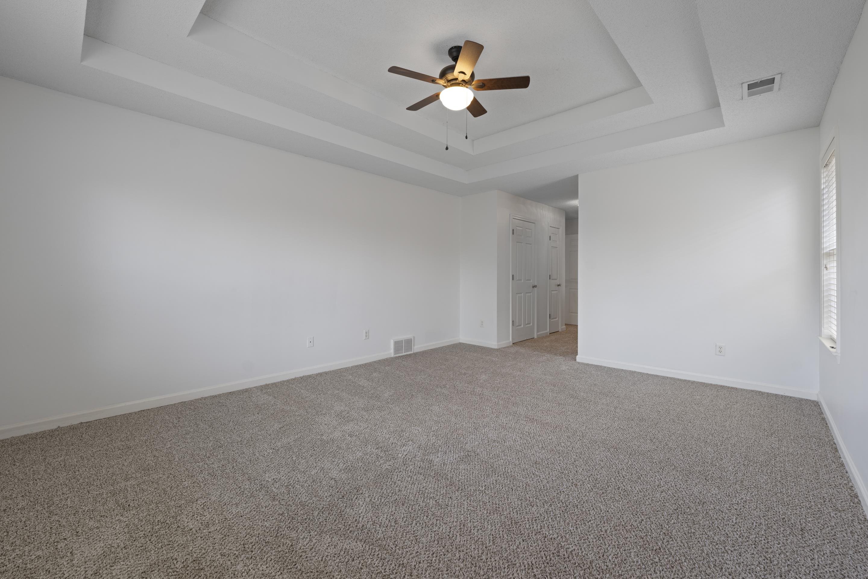 1104 Macon Hall Road Cordova, TN 38018 - Photo 14 of 34 Empty room with visible vents, baseboards, a ceiling fan, and a raised ceiling