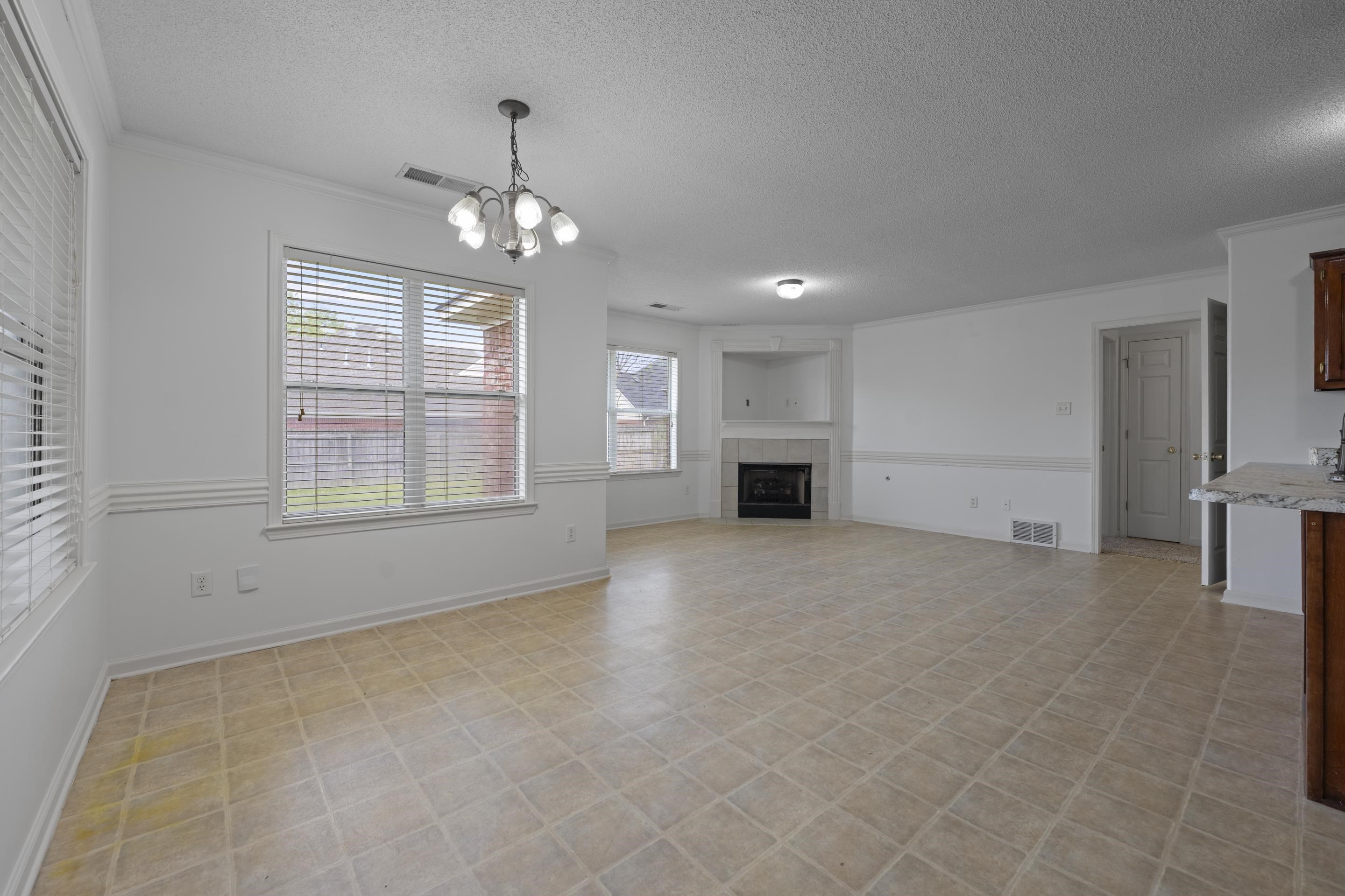 1104 Macon Hall Road Cordova, TN 38018 - Photo 15 of 34 Unfurnished living room featuring visible vents, an inviting chandelier, and a textured ceiling