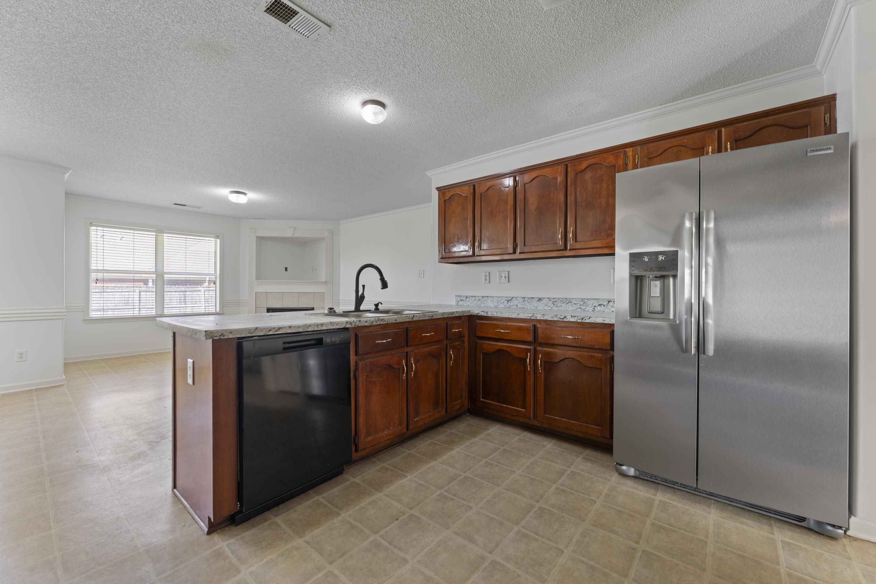 1104 Macon Hall Road Cordova, TN 38018 - Photo 20 of 34 Kitchen with a peninsula, stainless steel refrigerator with ice dispenser, visible vents, dishwasher, and a sink