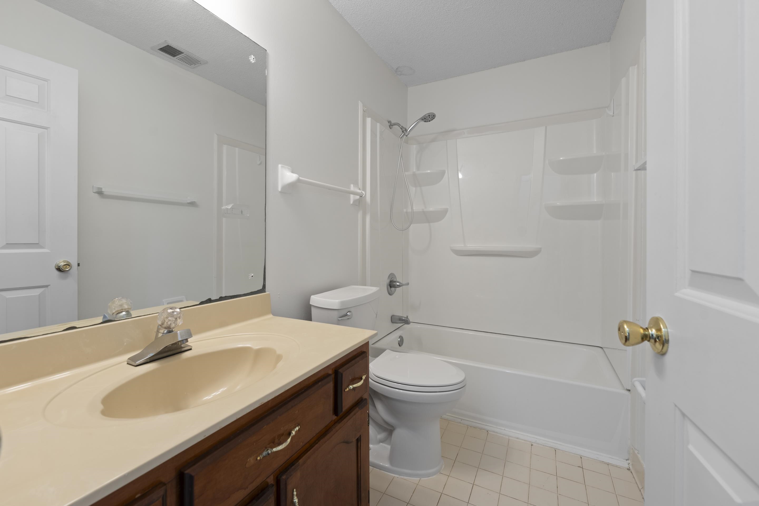 1104 Macon Hall Road Cordova, TN 38018 - Photo 23 of 34 Bathroom with washtub / shower combination, vanity, tile patterned floors, toilet, and visible vents