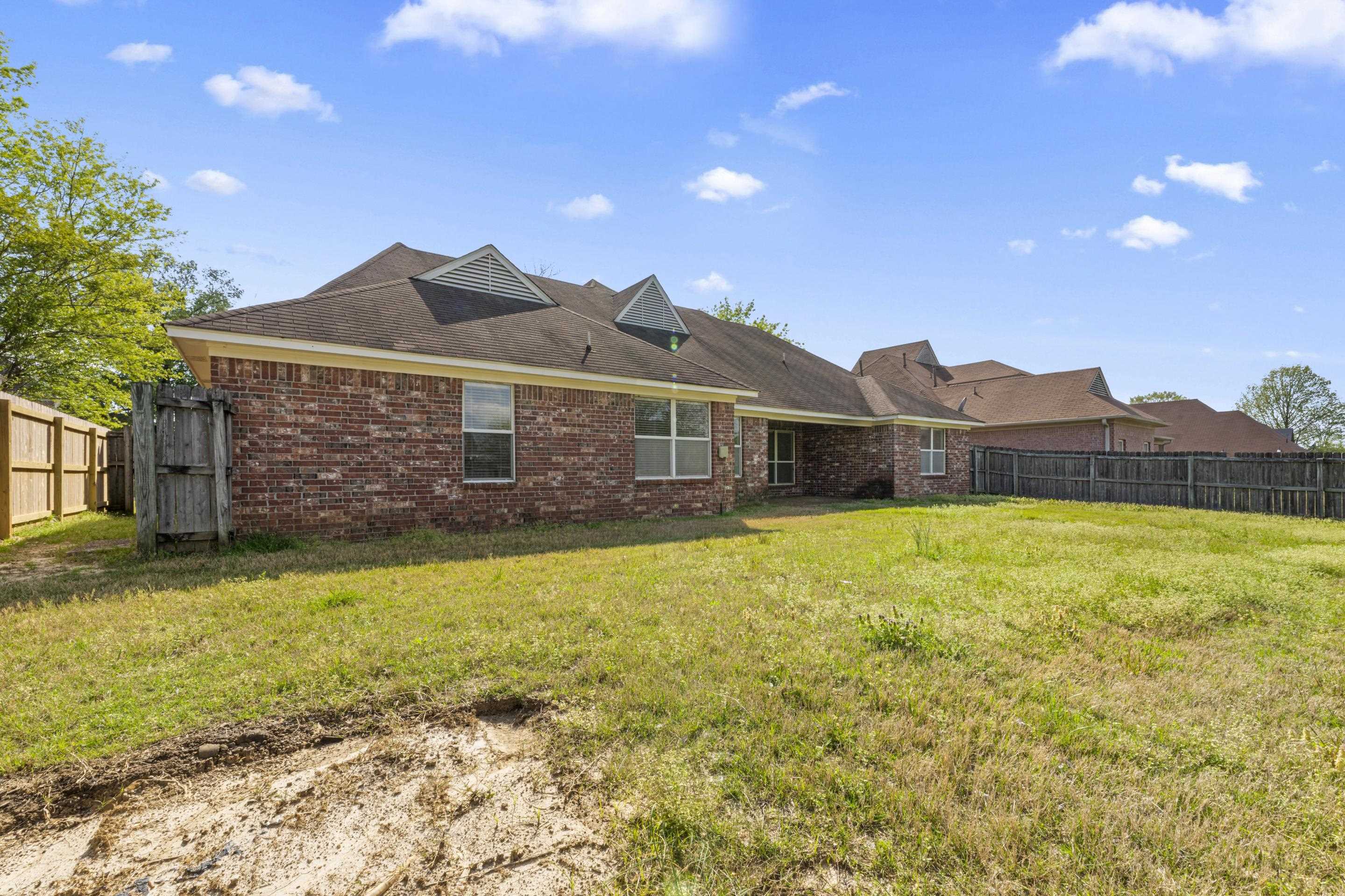 1104 Macon Hall Road Cordova, TN 38018 - Photo 29 of 34 Back of house featuring brick siding, a fenced backyard, and a yard
