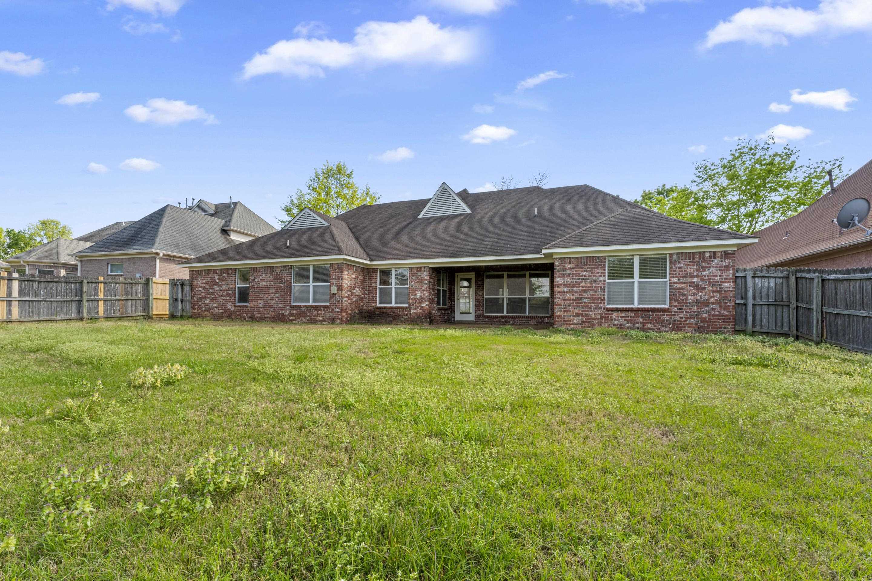 1104 Macon Hall Road Cordova, TN 38018 - Photo 31 of 34 Rear view of house featuring a yard, a fenced backyard, and brick siding
