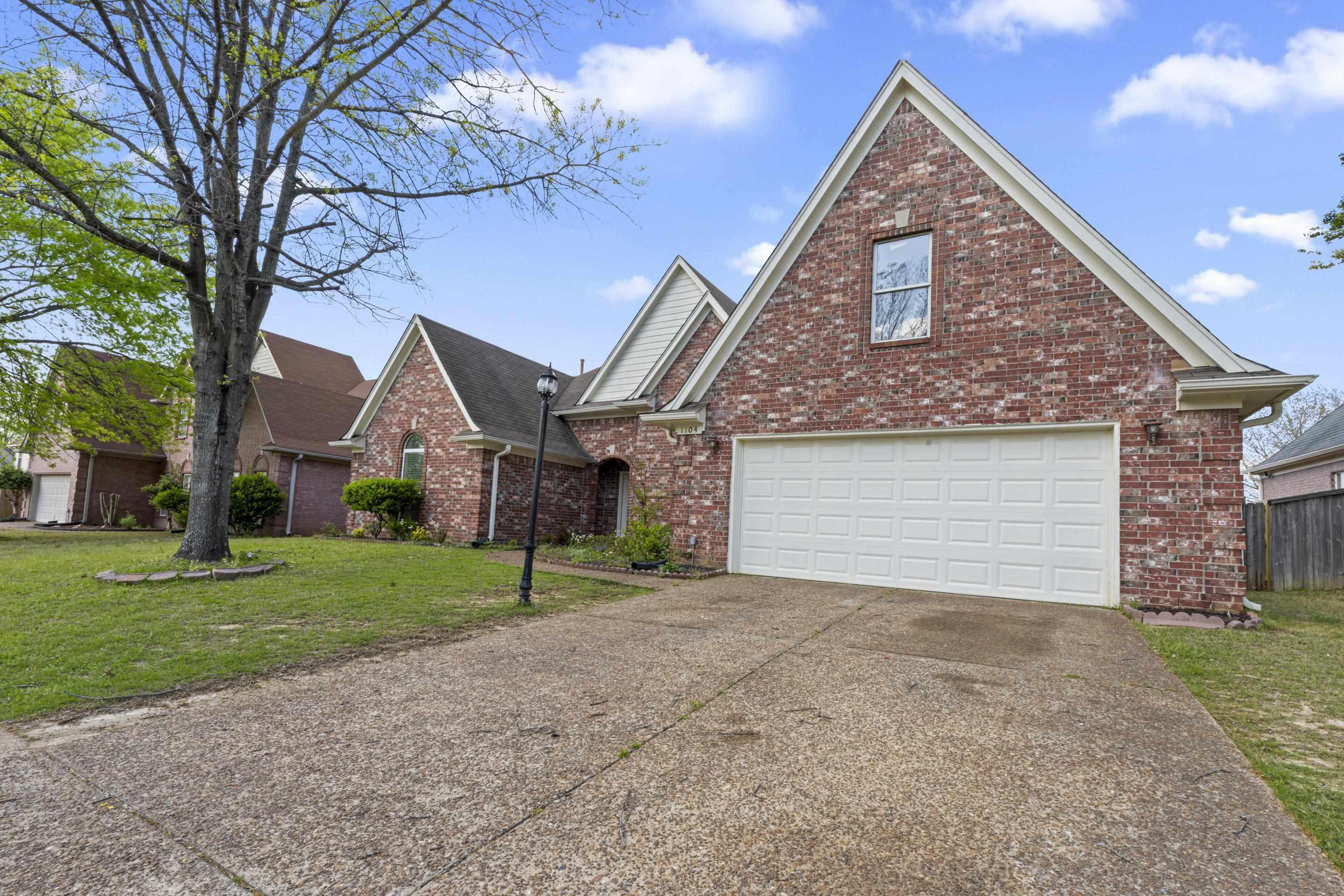 1104 Macon Hall Road Cordova, TN 38018 - Photo 34 of 34 Traditional-style house featuring brick siding, driveway, a garage, and a front yard