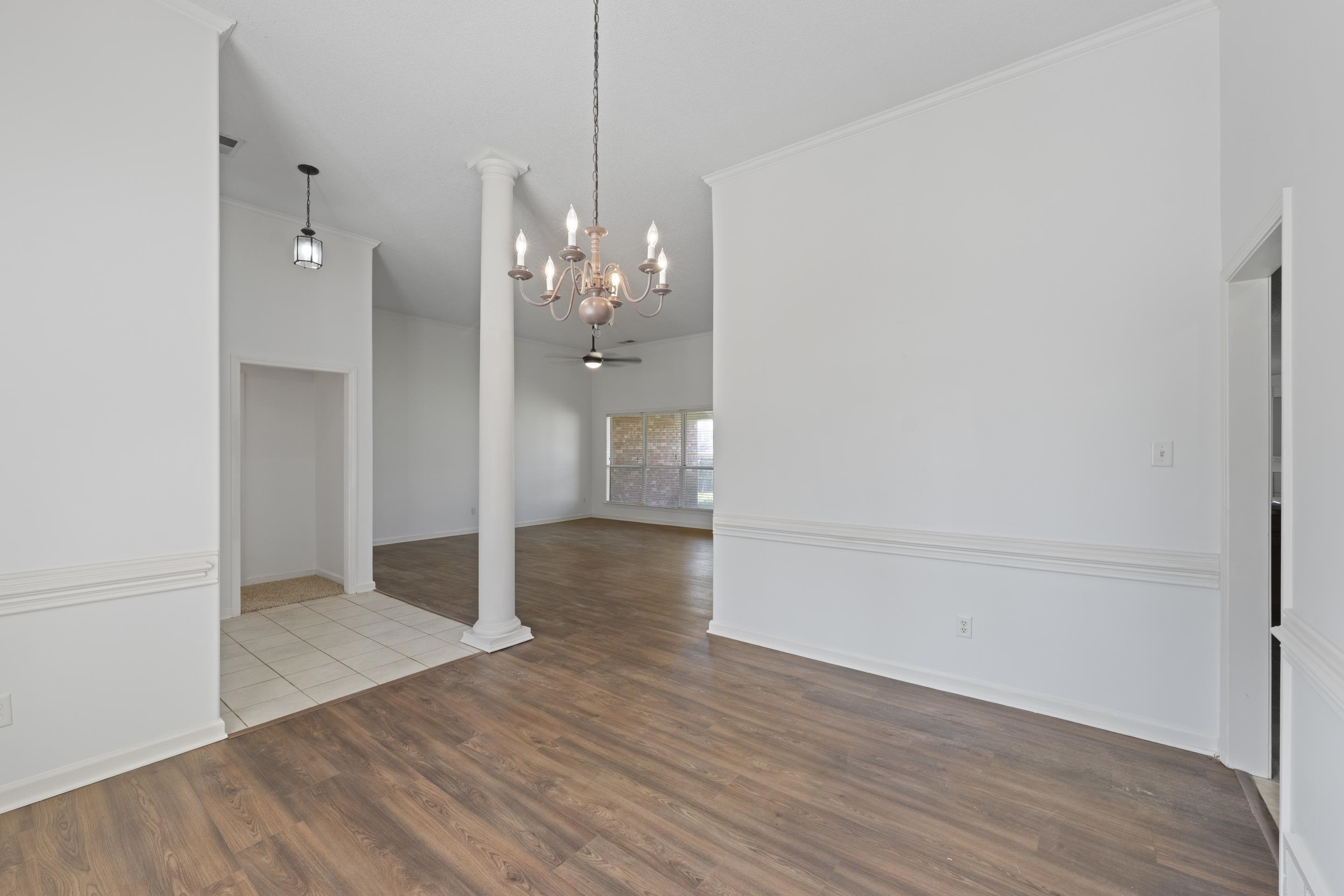 1104 Macon Hall Road Cordova, TN 38018 - Photo 4 of 34 Unfurnished dining area featuring a notable chandelier, ornate columns, baseboards, and wood finished floors
