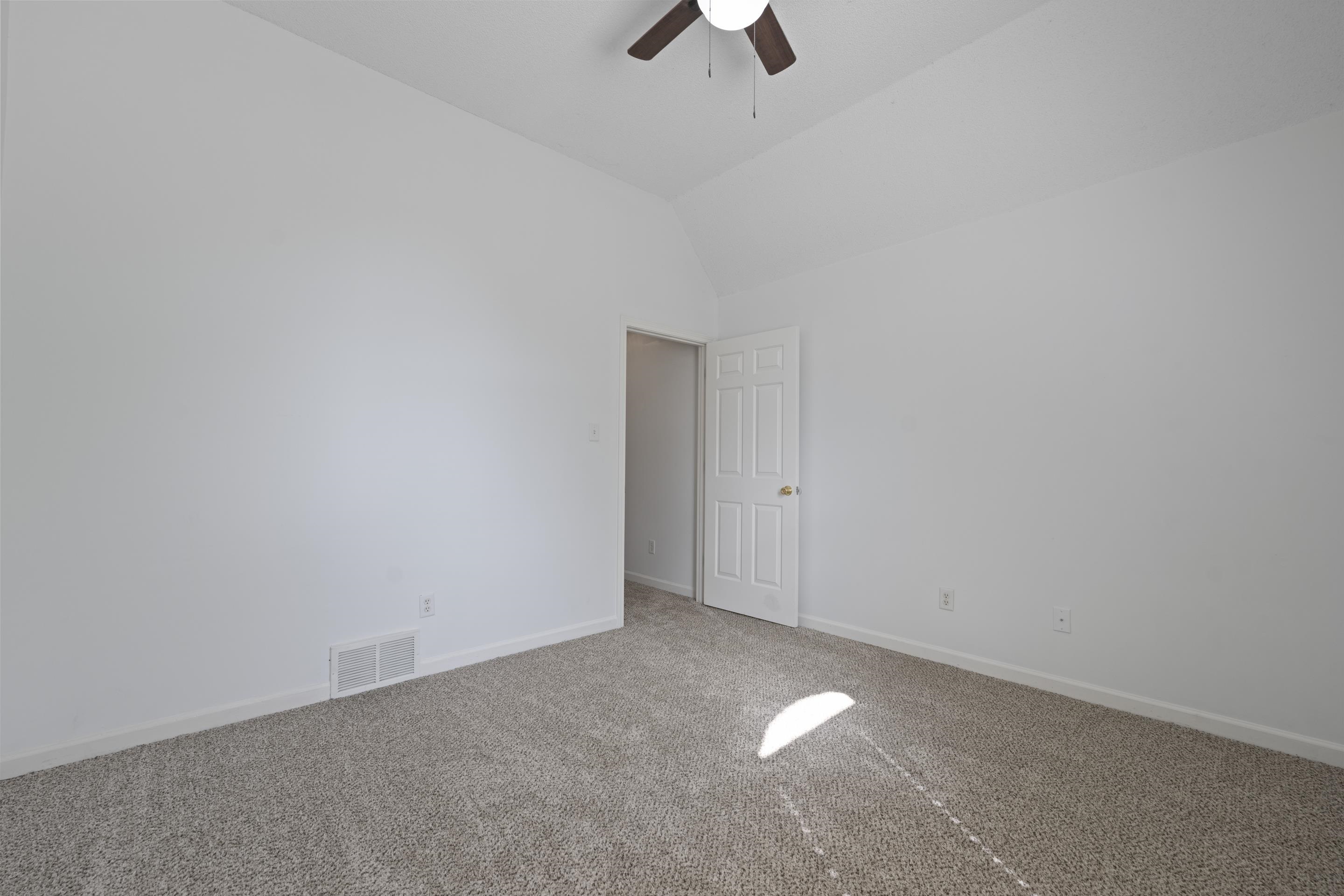 1104 Macon Hall Road Cordova, TN 38018 - Photo 8 of 34 Carpeted empty room featuring visible vents, baseboards, vaulted ceiling, and ceiling fan