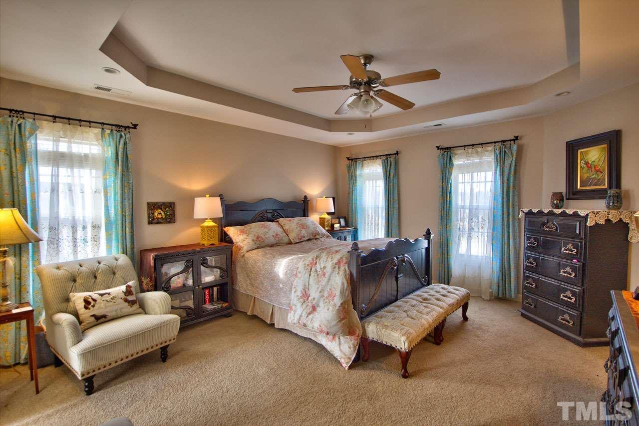 1021 Newburgh Circle Raleigh, NC 27603 - Photo 14 of 25 a spacious bedroom with a bed a couch and a chandelier