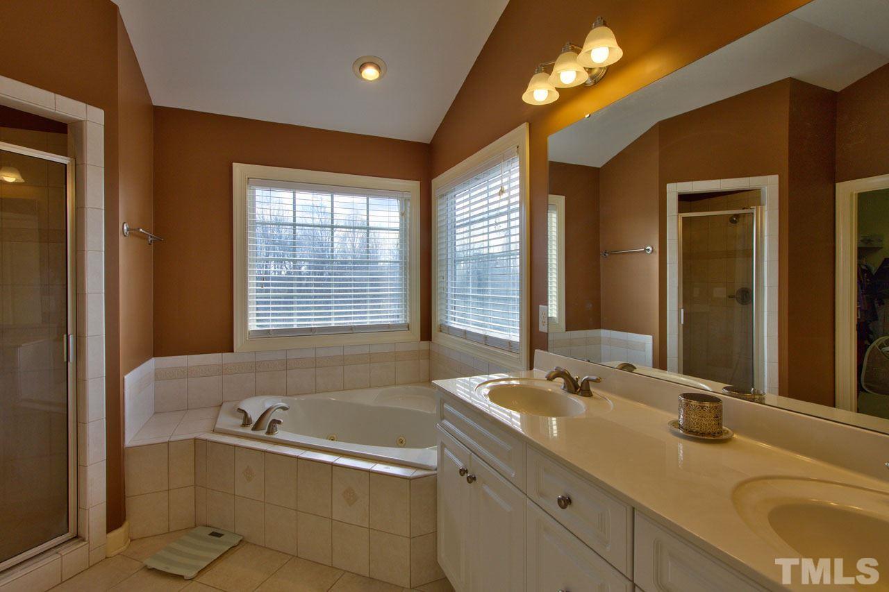 1021 Newburgh Circle Raleigh, NC 27603 - Photo 16 of 25 a bathroom with a granite countertop tub sink and mirror