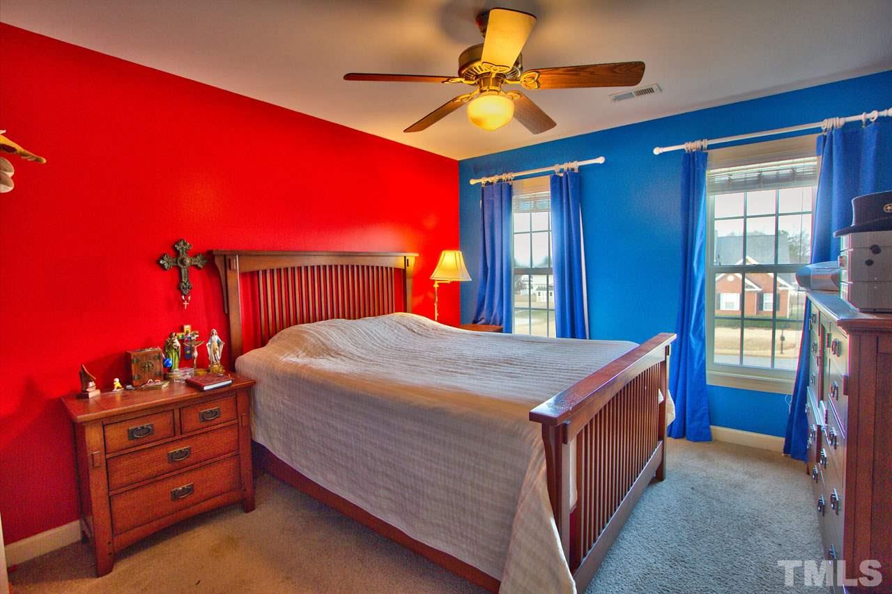 1021 Newburgh Circle Raleigh, NC 27603 - Photo 19 of 25 a bed room with a bed and a chandelier