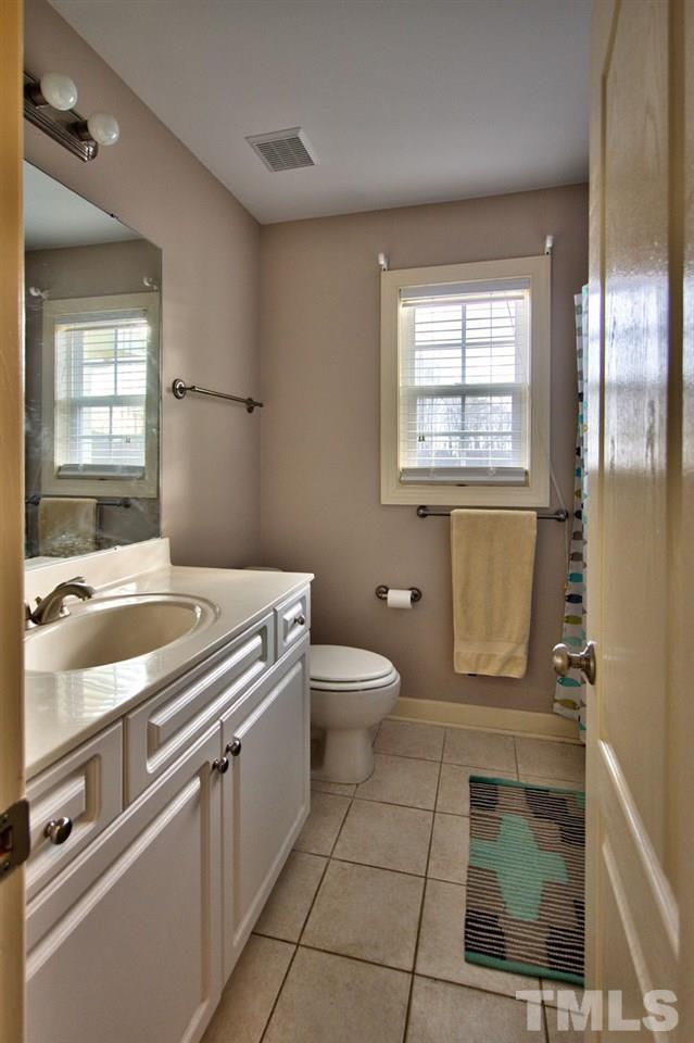1021 Newburgh Circle Raleigh, NC 27603 - Photo 21 of 25 a bathroom with a granite countertop sink toilet and mirror