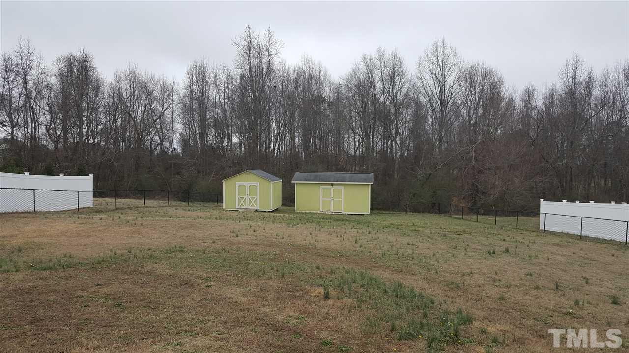 1021 Newburgh Circle Raleigh, NC 27603 - Photo 24 of 25 a backyard of a house with large trees and wooden fence