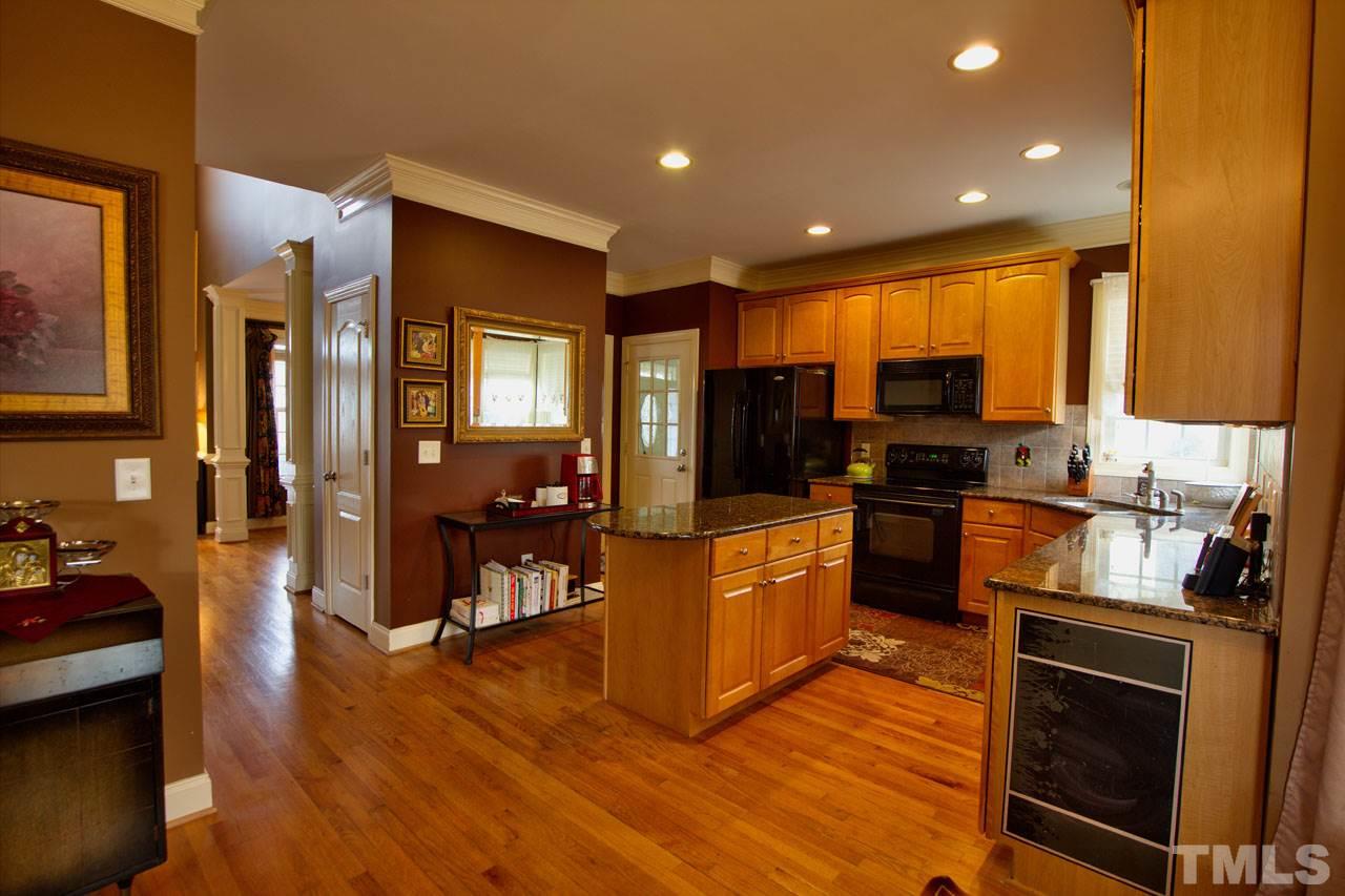 1021 Newburgh Circle Raleigh, NC 27603 - Photo 8 of 25 a kitchen with stainless steel appliances granite countertop a stove top oven a sink dishwasher a refrigerator and cabinets with wooden floor