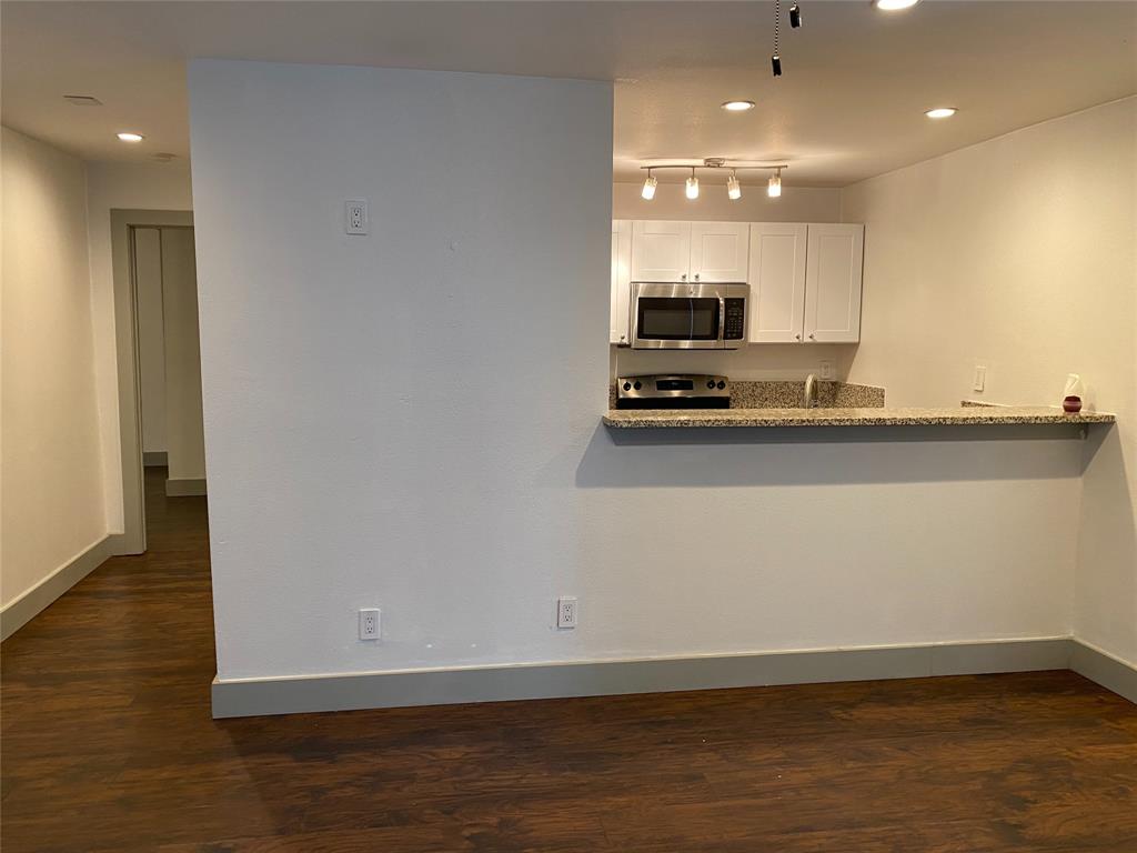 a view of a kitchen with a sink wooden cabinets and a refrigerator