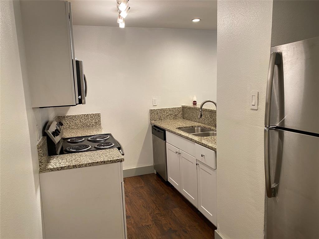 4633 Fairmount Street, Unit 110 Dallas, TX 75219 - Photo 2 of 13 a kitchen with a stove a refrigerator and a sink