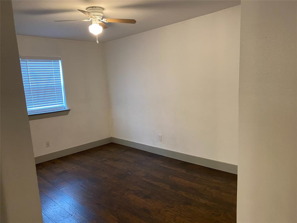 4633 Fairmount Street, Unit 110 Dallas, TX 75219 - Photo 5 of 13 an empty room with wooden floor and fan