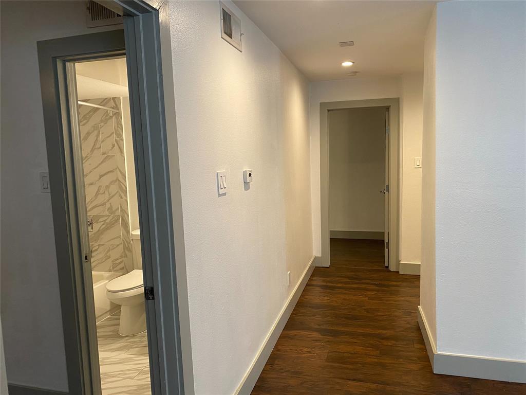 4633 Fairmount Street, Unit 110 Dallas, TX 75219 - Photo 8 of 13 a view of a hallway with wooden floor and a bathroom