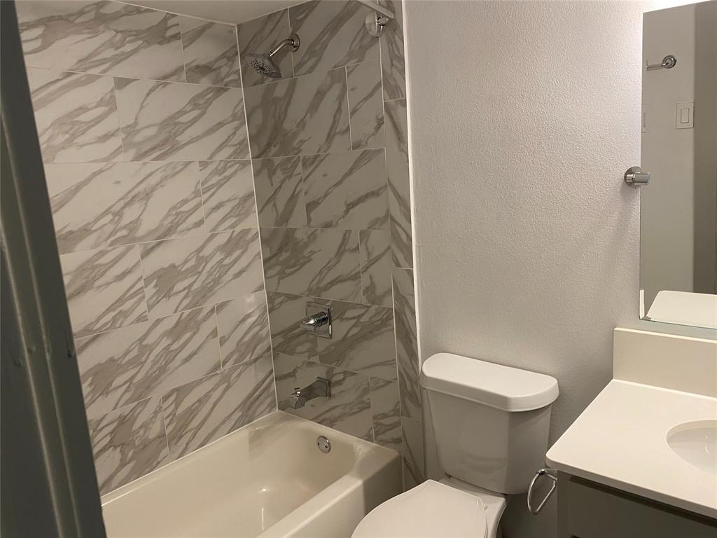 4633 Fairmount Street, Unit 110 Dallas, TX 75219 - Photo 9 of 13 a white toilet sitting next to a shower