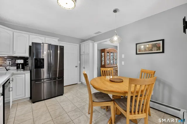 a kitchen with stainless steel appliances granite countertop a dining table and chairs