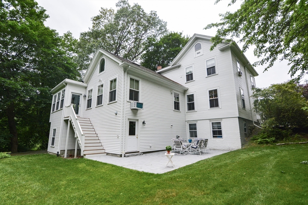 37 Pemberton Road Wayland, MA 01778 - Photo 31 of 34 a view of a white house with a yard and lawn chairs