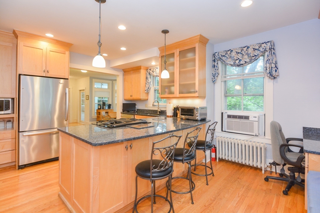 37 Pemberton Road Wayland, MA 01778 - Photo 5 of 34 a kitchen with stainless steel appliances granite countertop a refrigerator a sink a stove and a dining table with wooden floor
