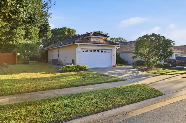a view of a big house with a big yard and large trees