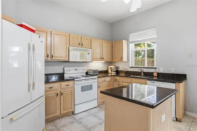 a kitchen with granite countertop a sink stove and refrigerator
