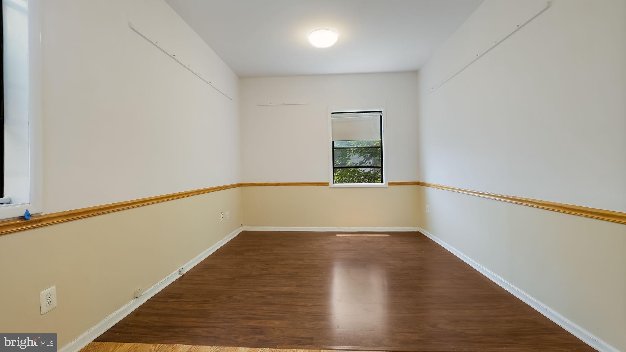 2120 South Street, Unit 2RE Philadelphia, PA 19146 - Photo 16 of 20 a view of an empty room with wooden floor and a window