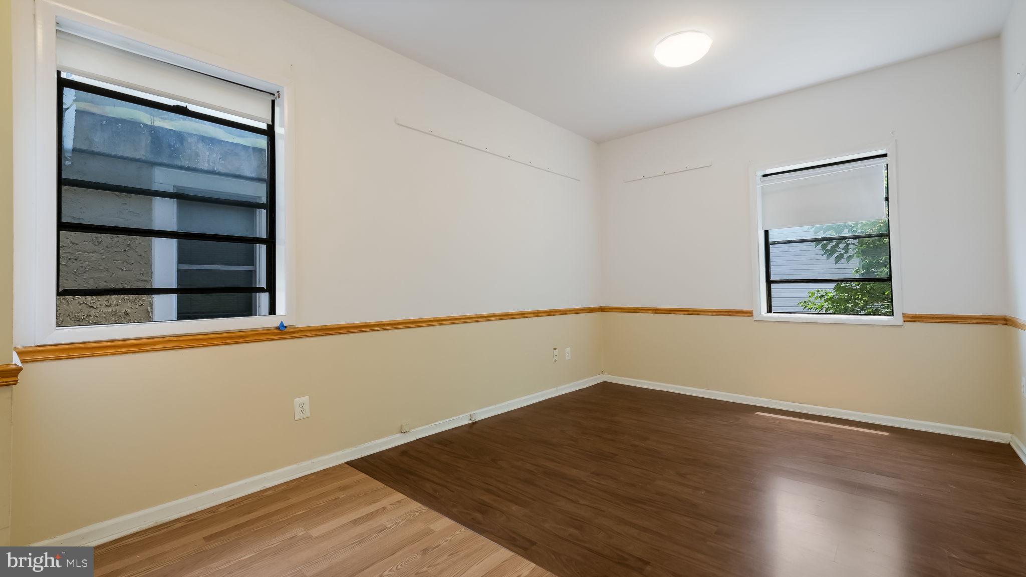 2120 South Street, Unit 2RE Philadelphia, PA 19146 - Photo 18 of 20 a view of an empty room with wooden floor and a window